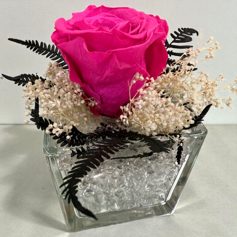 Rosa fucsia stabilizzata in vasetto di vetro con ornamenti