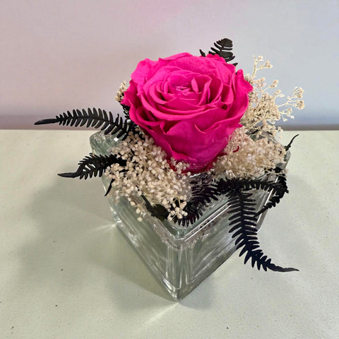 Rosa fucsia stabilizzata in vasetto di vetro con ornamenti